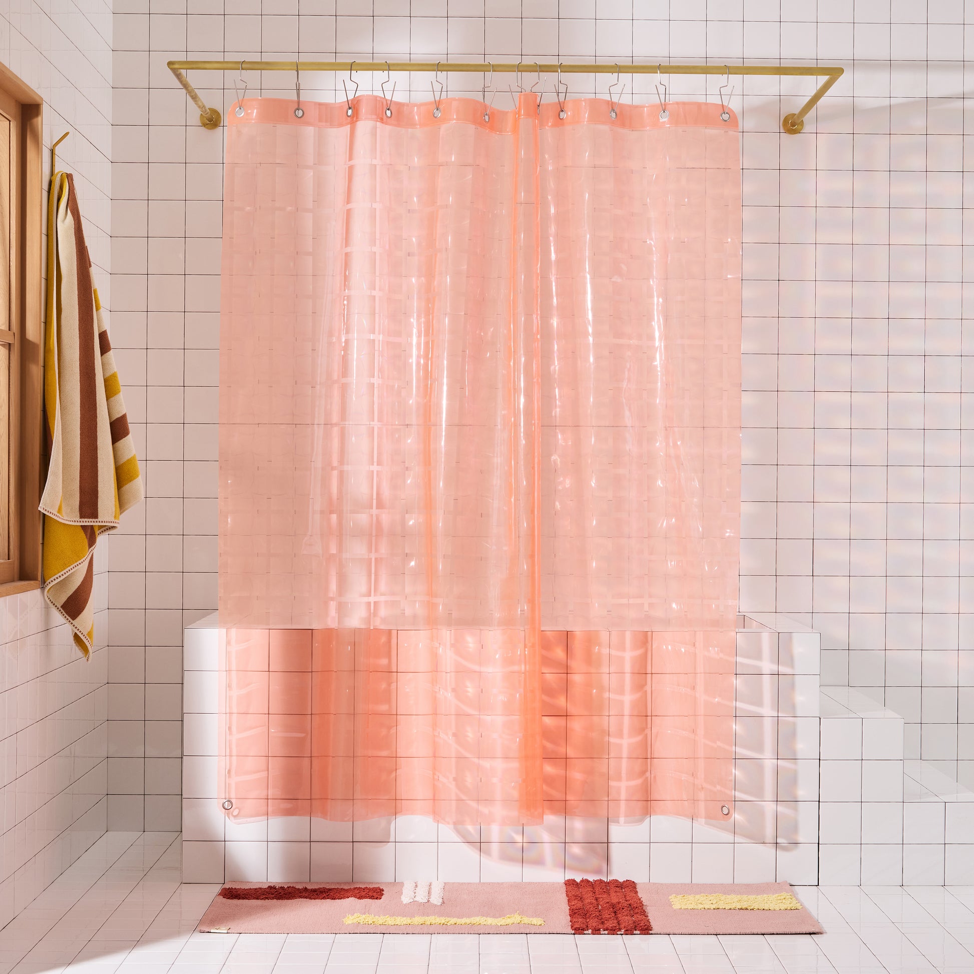 Light pink 3D shower curtain hanging in white tiled bathroom.