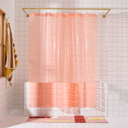 Light pink 3D shower curtain hanging in white tiled bathroom.