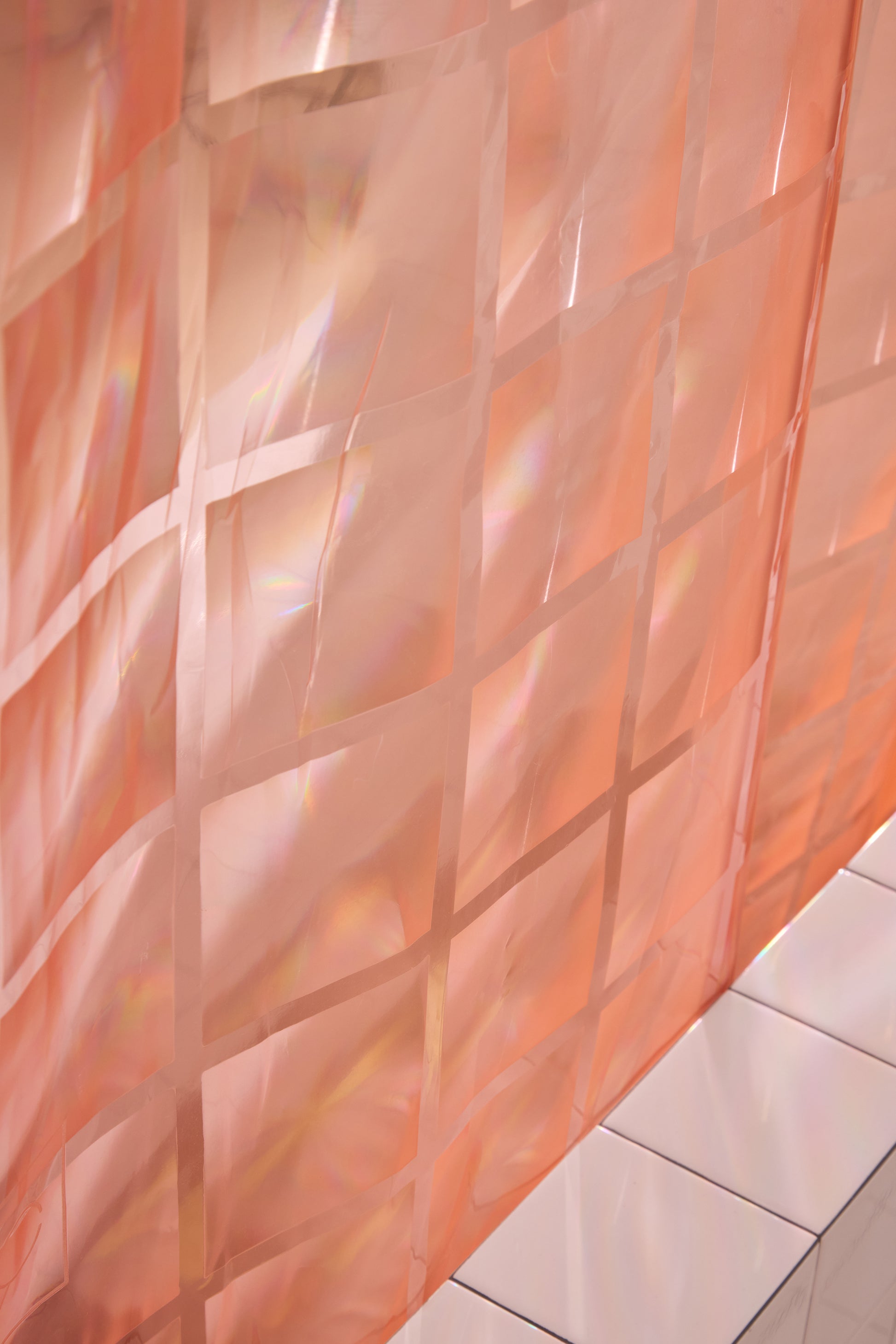 Detail of Light pink 3D printed shower curtain hanging in white tiled bathroom. 