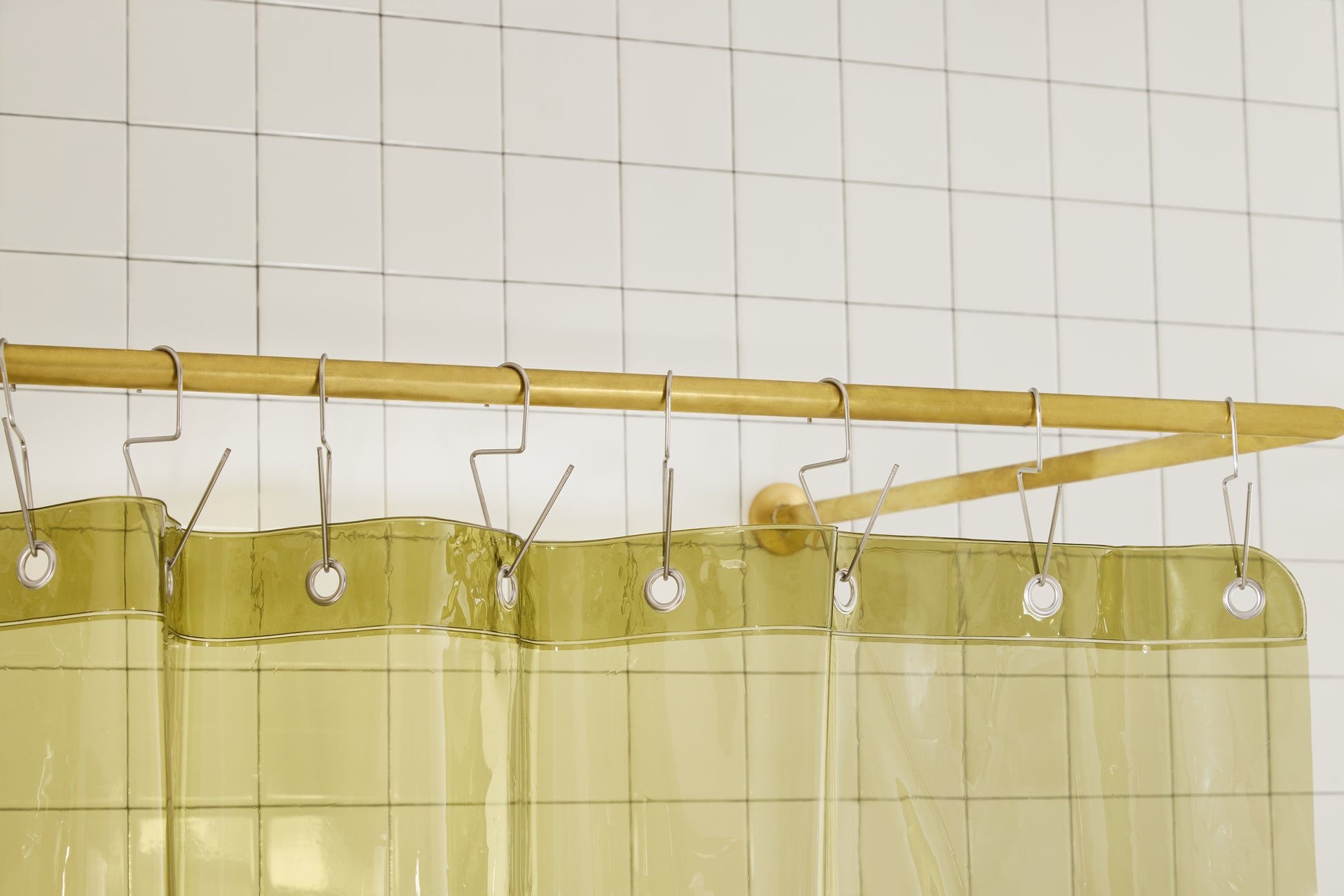 Sun Shower in Olive detail view of grommets and hooks hanging from shower curtain rod.