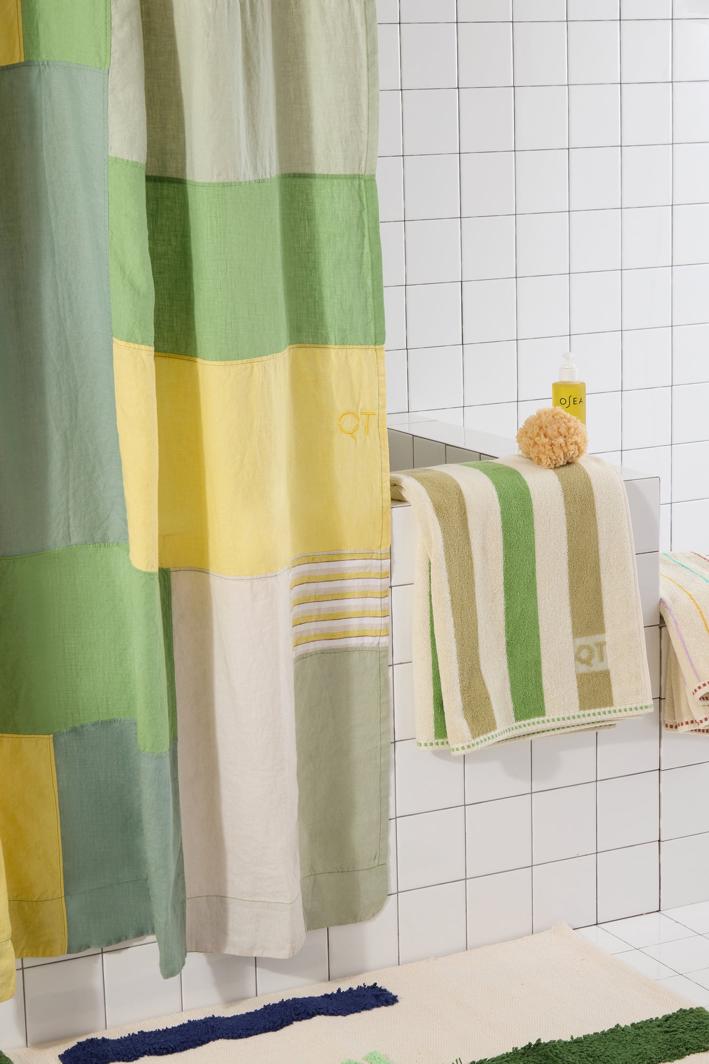 Colorful patchwork shower curtain and towels in a bathroom setting.