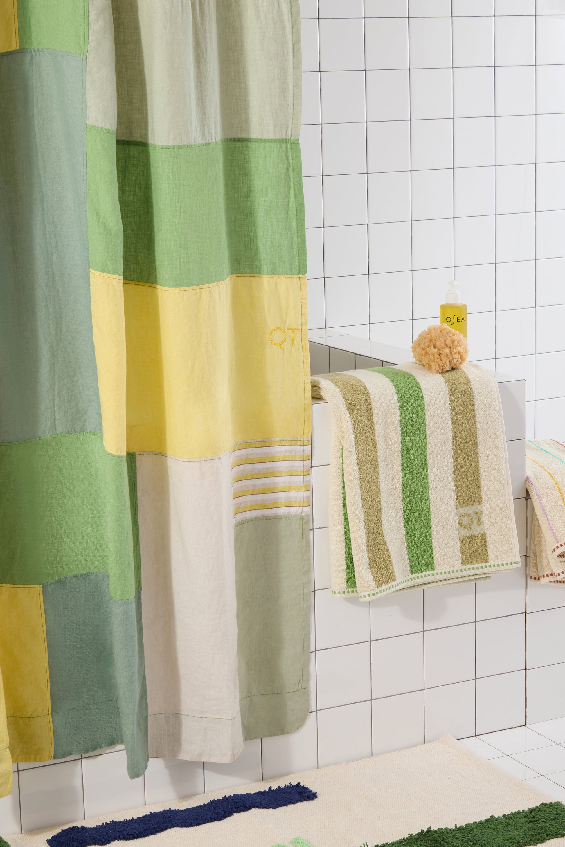 Colorful patchwork shower curtain and towels in a bathroom setting.
