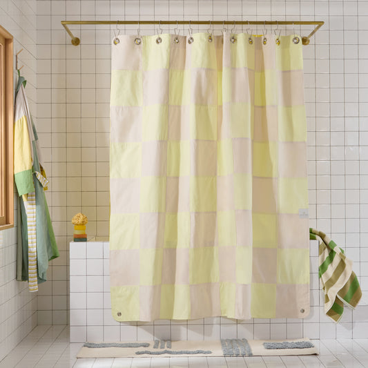 Checkered shower curtain in a bathroom with tiled walls and a bathtub.