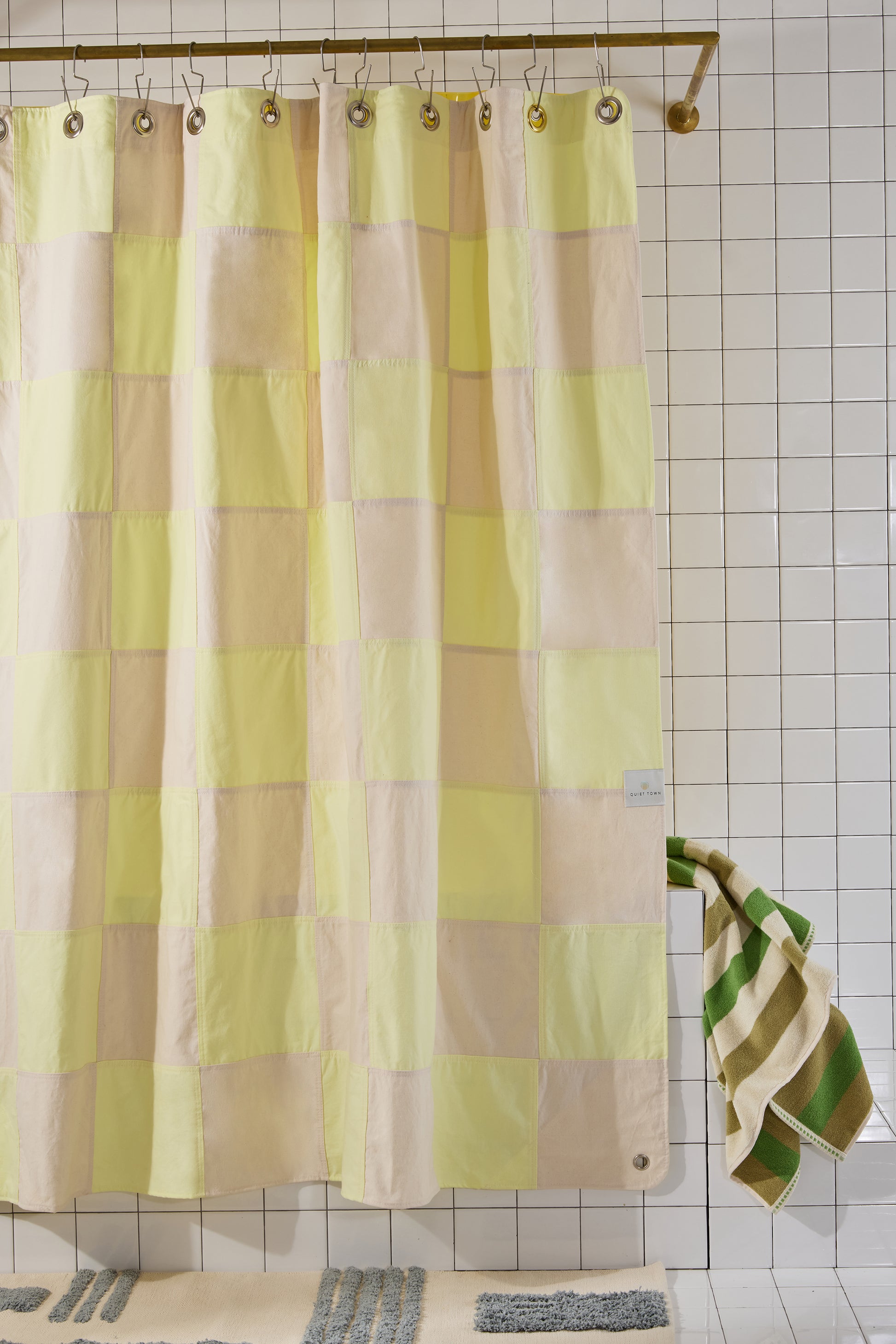 Checkered shower curtain with a yellow and cream pattern in a bathroom setting.