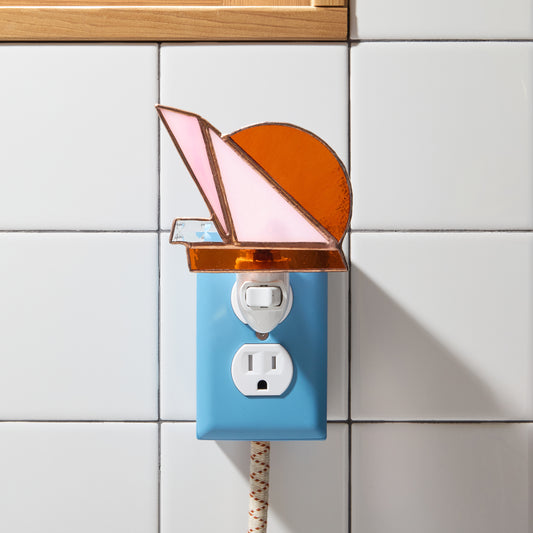 Colorful night light with a stained glass design on a tiled wall.