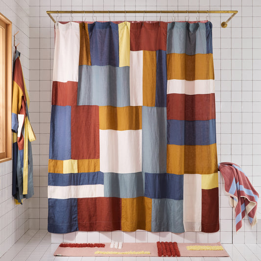 multicolor linen curtain hanging in white bathroom