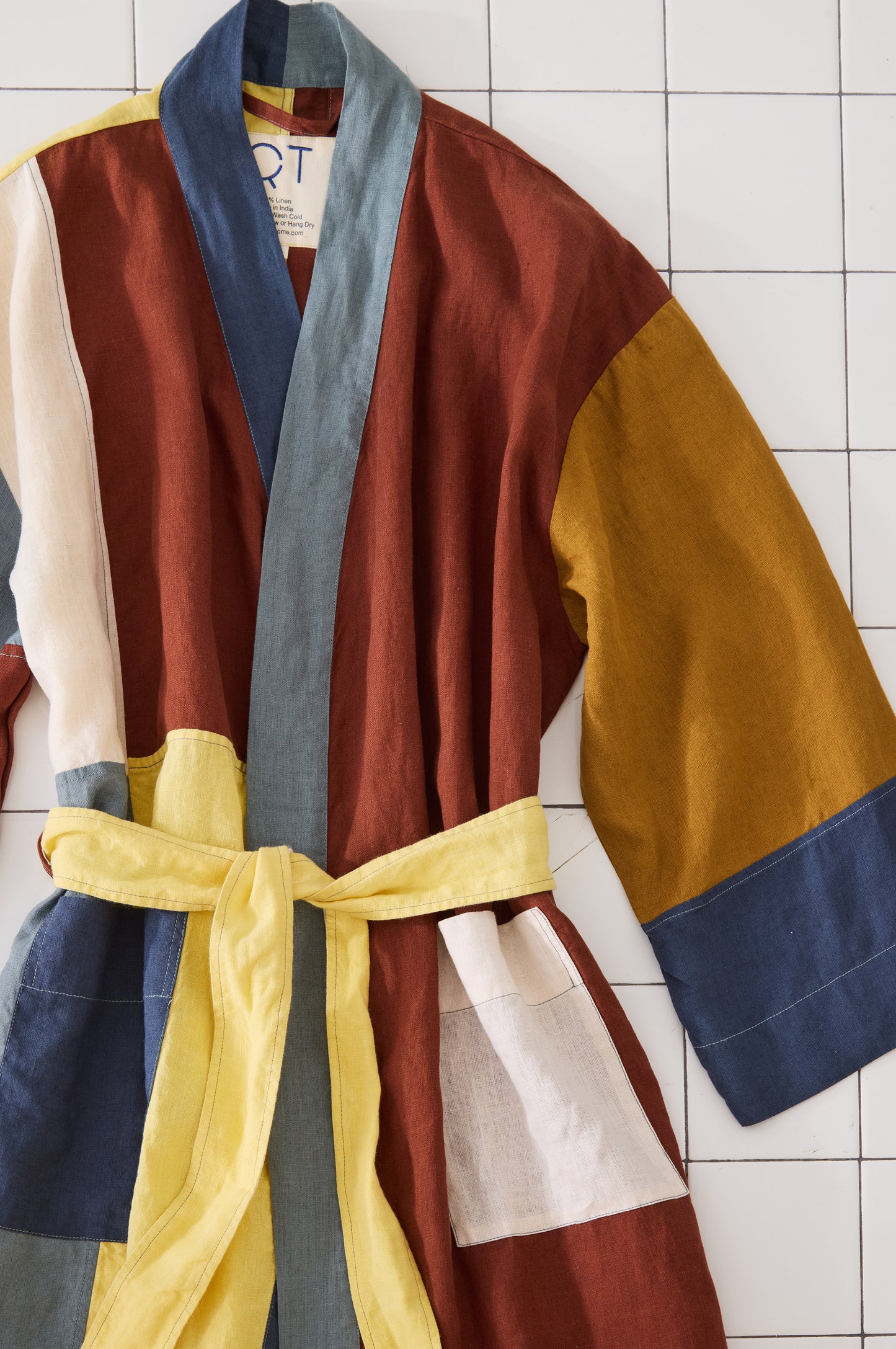 Colorful robe with a belt on a tiled wall background
