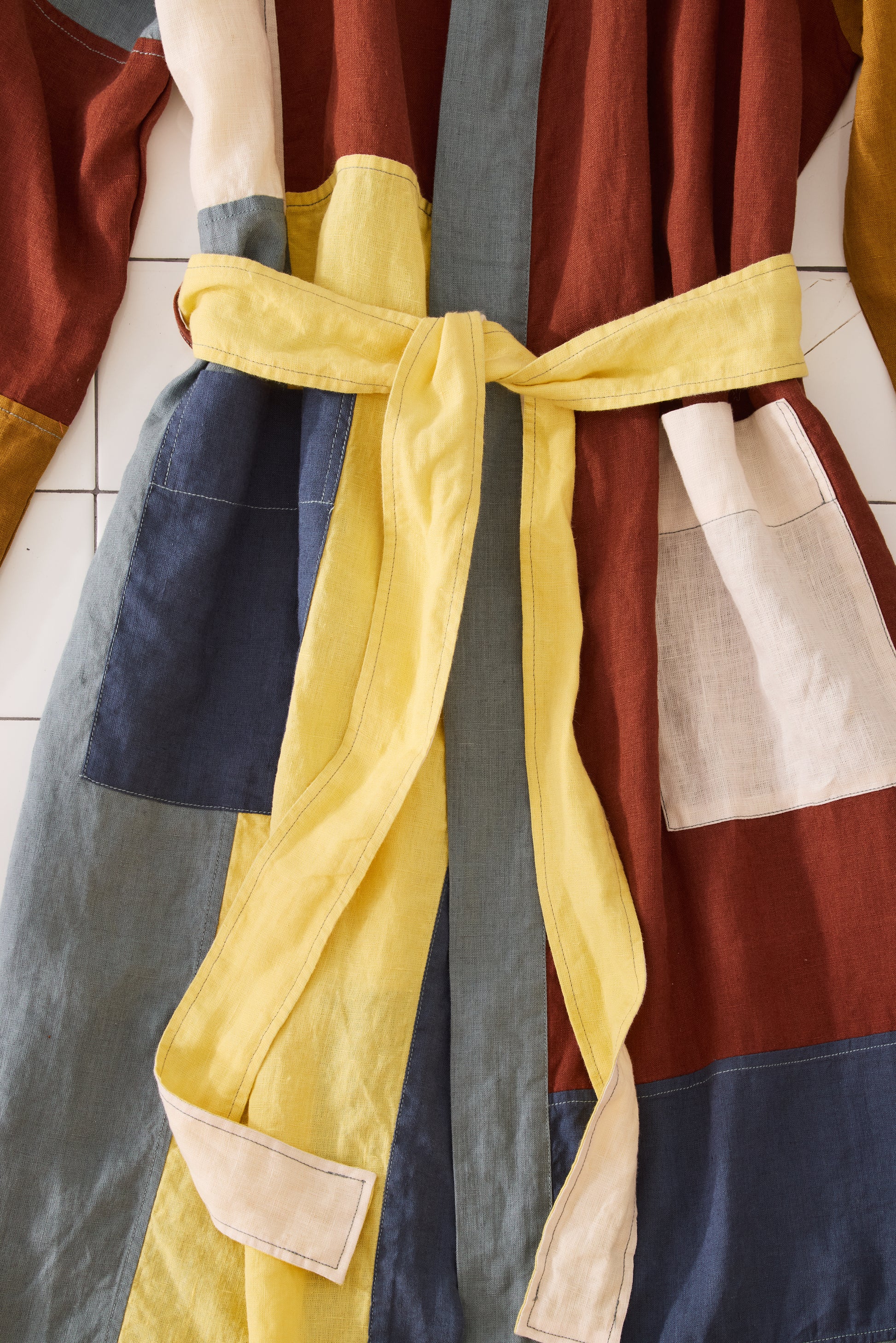 Colorful robe with a yellow tie on a tiled wall background