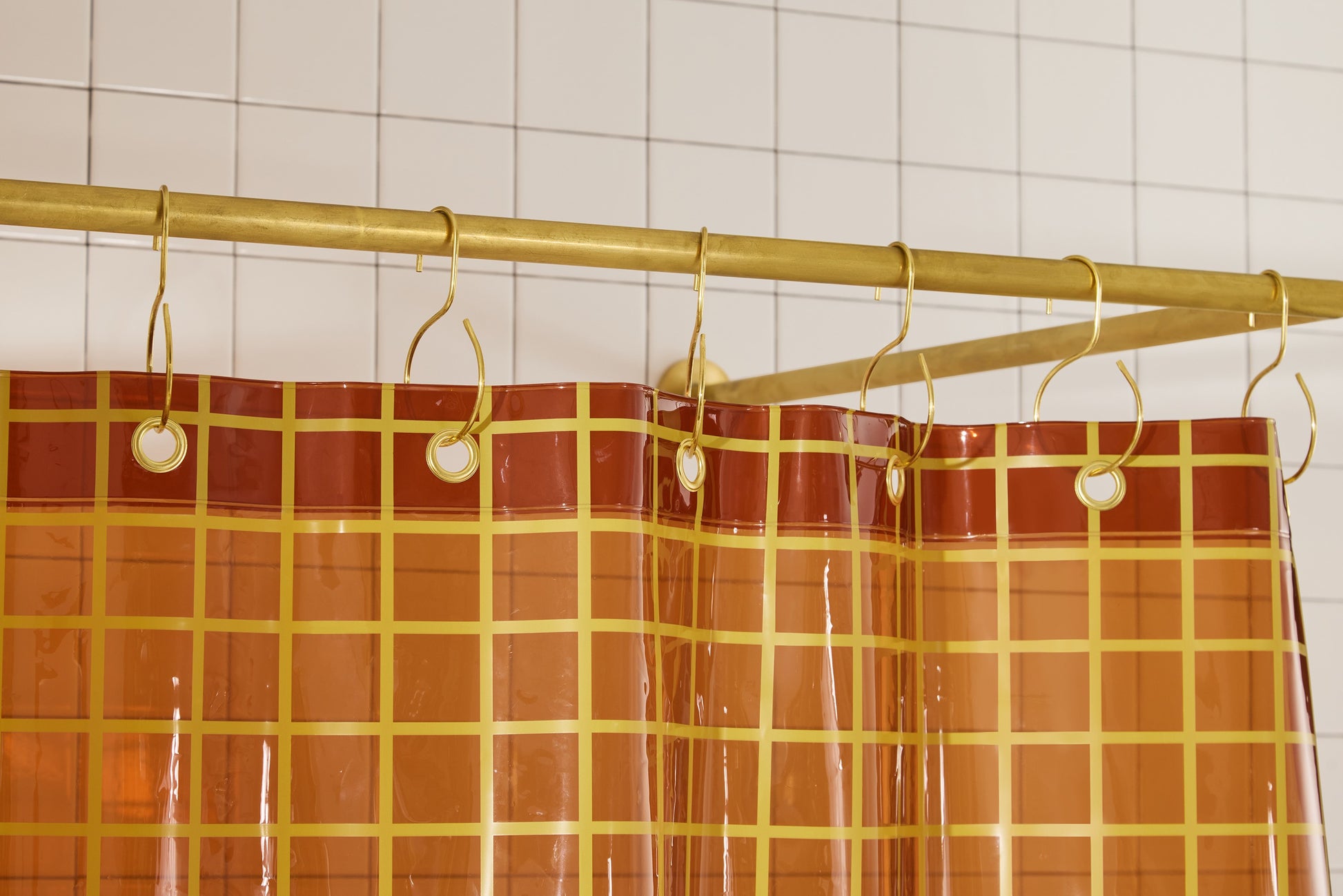 Sun Shower in Honey 2x2 detail view of grommets and hooks hanging from shower curtain rod.