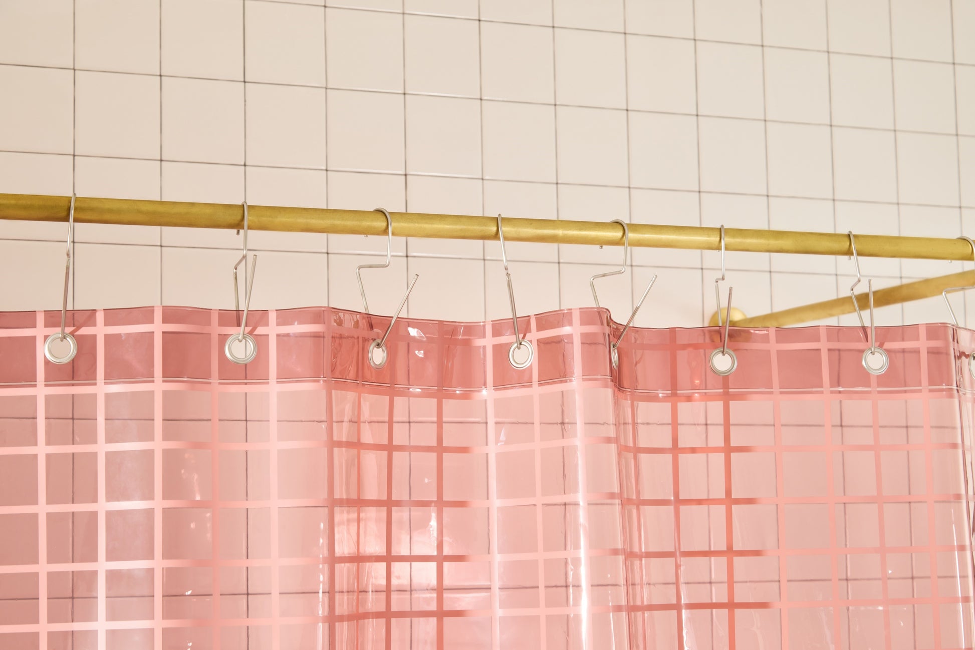 Sun Shower in Rose 2x2 detail view of grommets and hooks hanging from shower curtain rod.