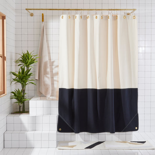 Shower curtain with white top and black bottom in a bathroom setting