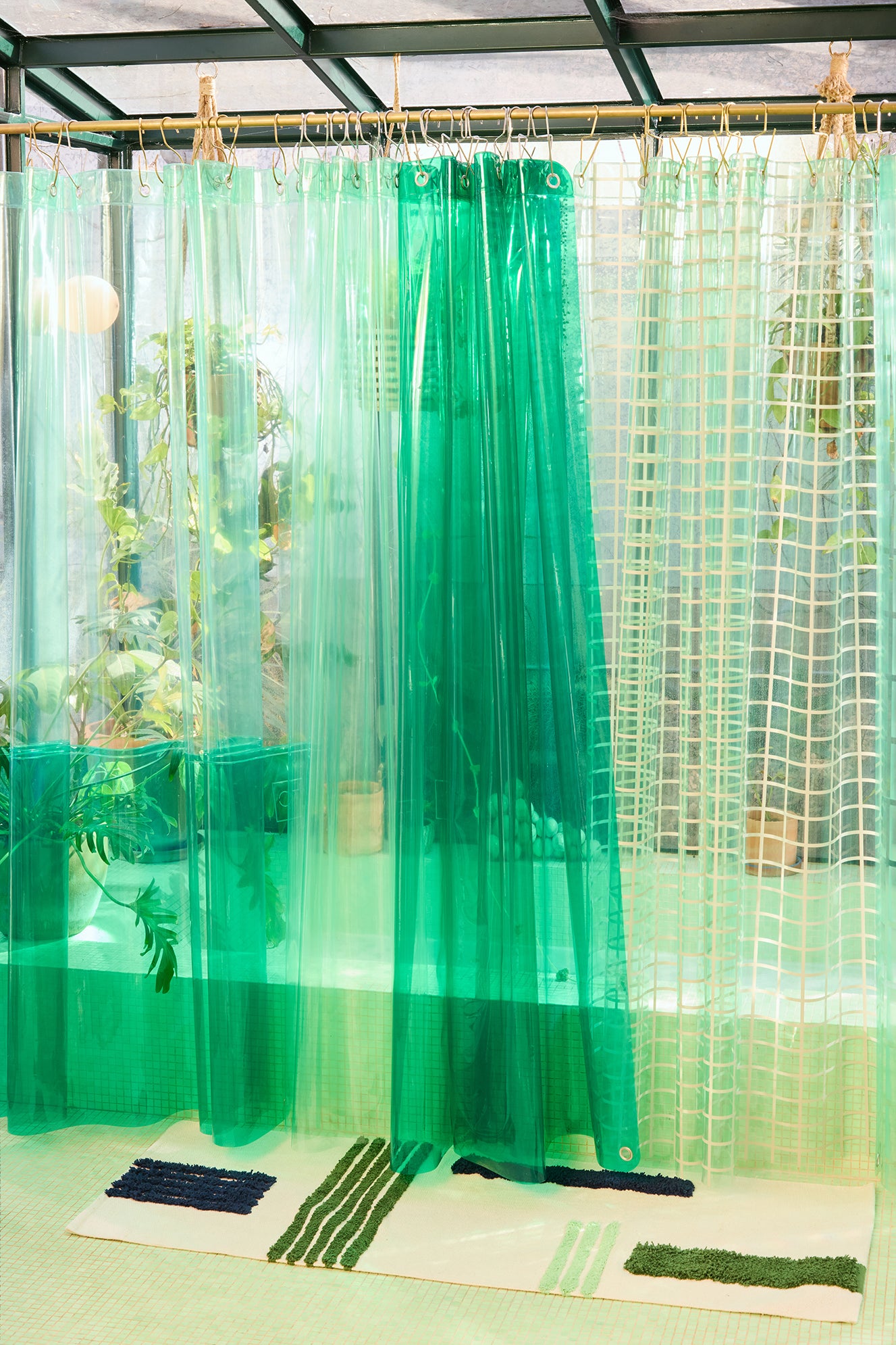 Green transparent curtains in a room with plants and a rug.