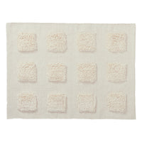 cream textured bath rug on a white background. 