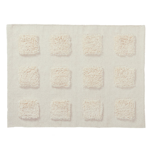 cream textured bath rug on a white background. 