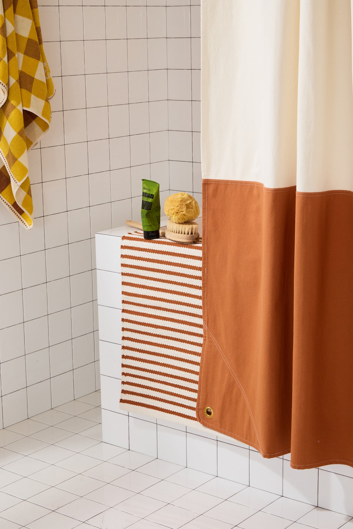 Bottom corner detail ofOrient Clay  colorblock shower curtain with brass grommet.
