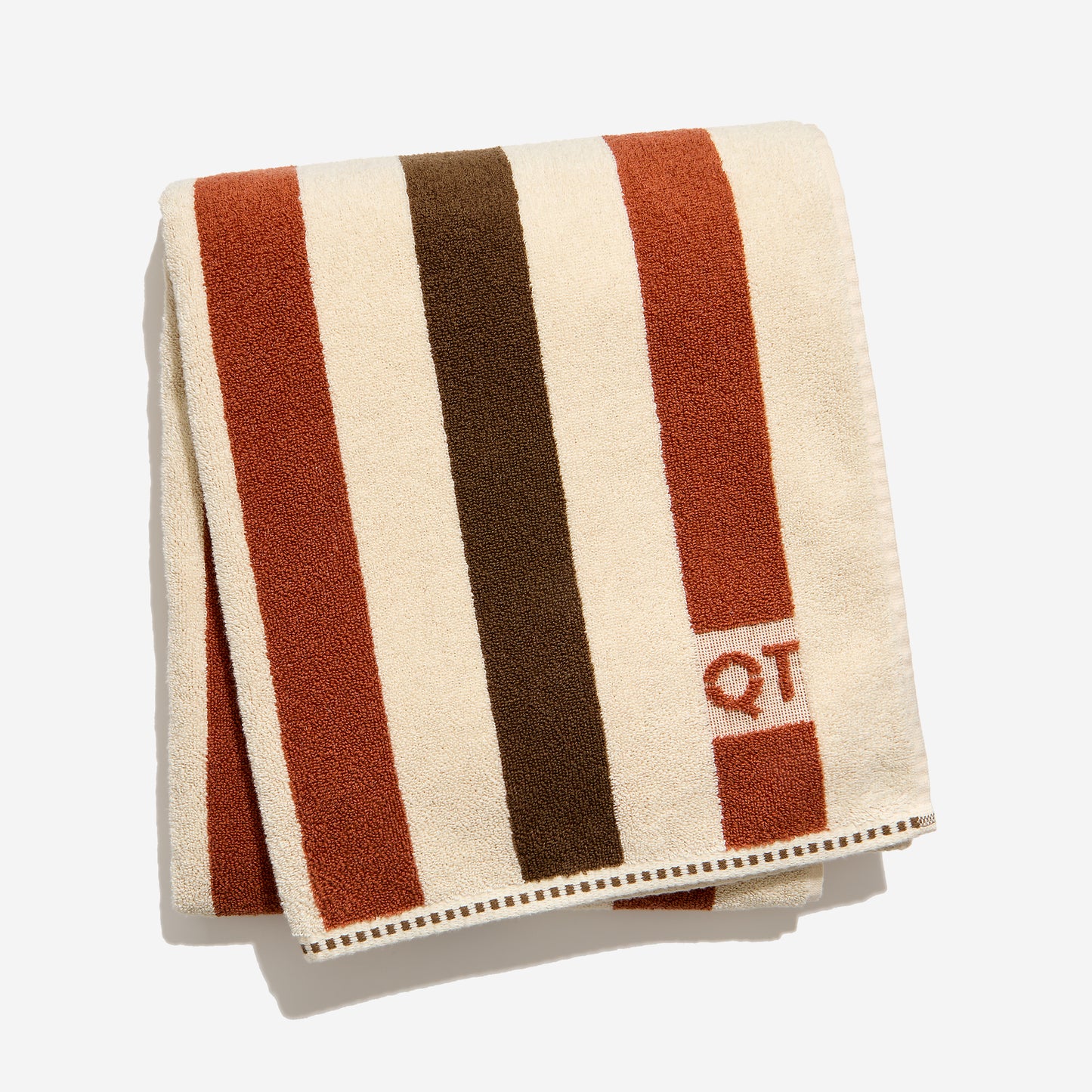 Striped towel with brown, clay, and cream colors and 'QT' logo on a white background