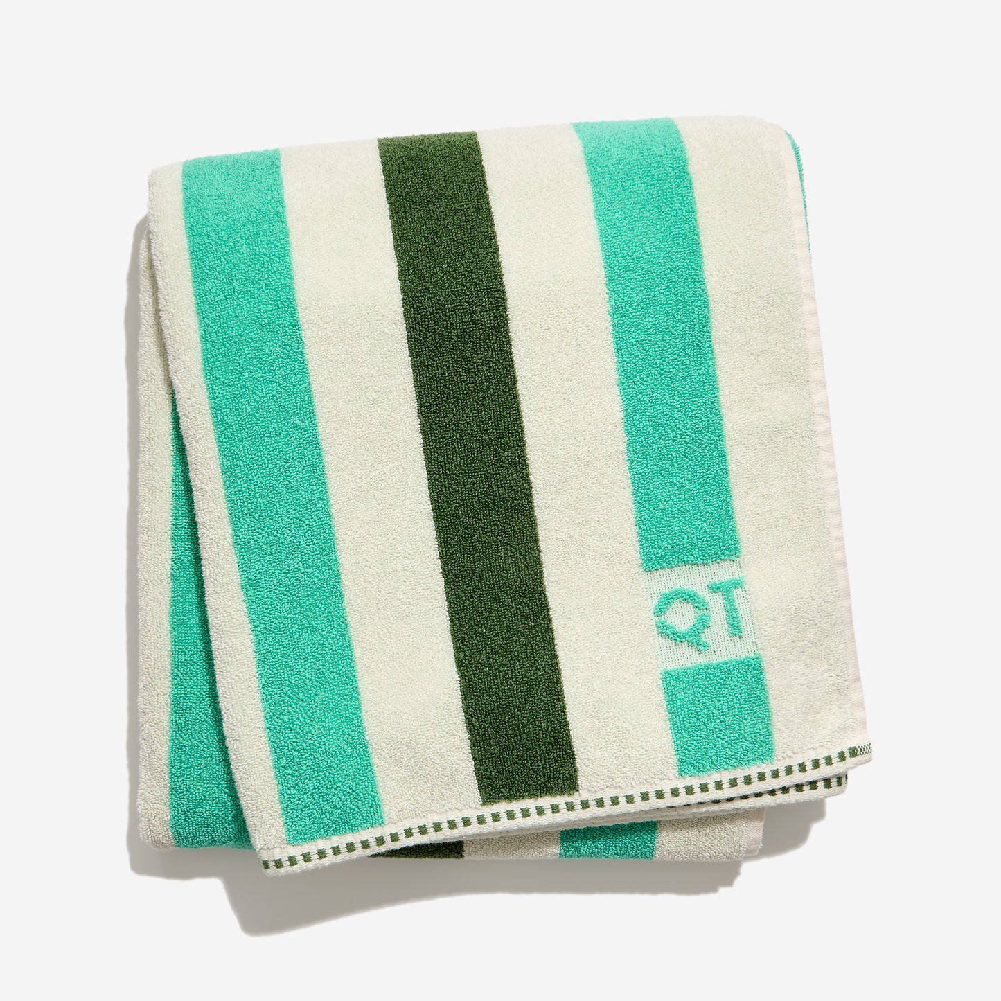Folded towel with green and teal and cream stripes on a white background