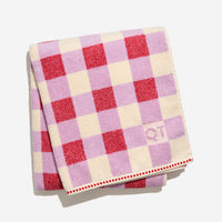 Tam bath sheet in candy folded against white background.