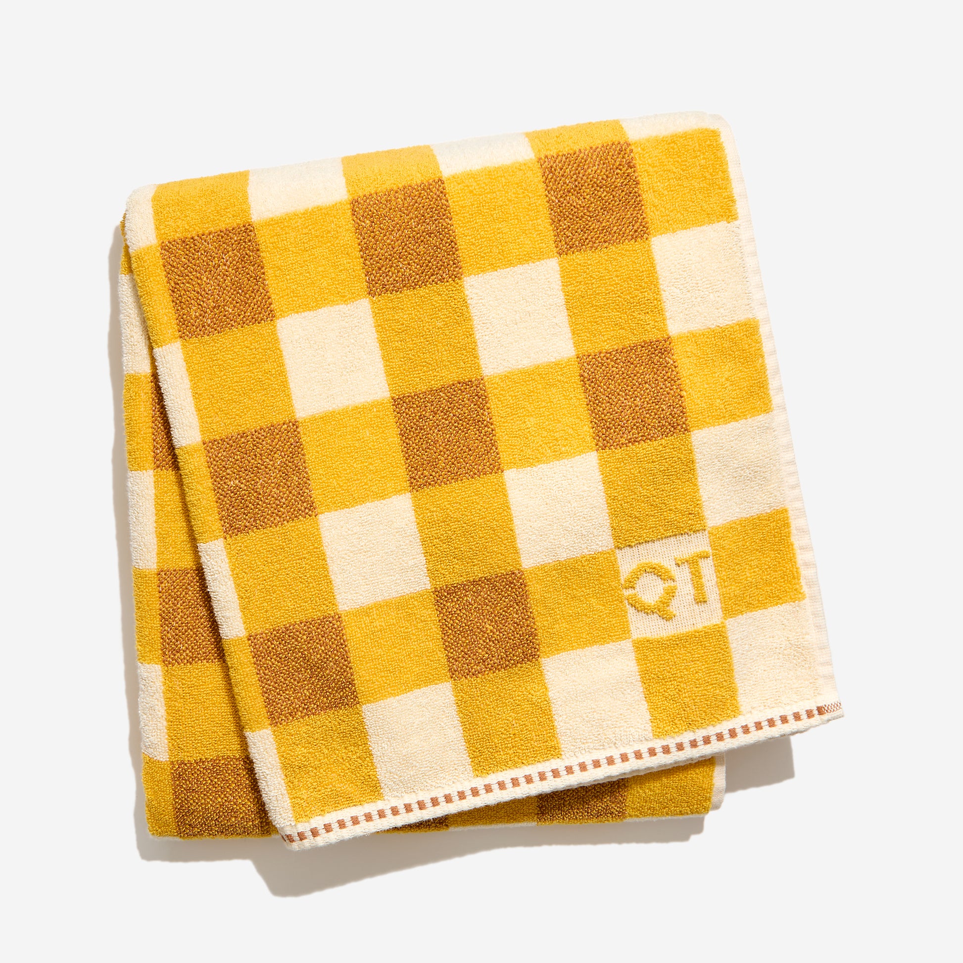 Yellow and  clay and cream checkered towel with a logo on a white background