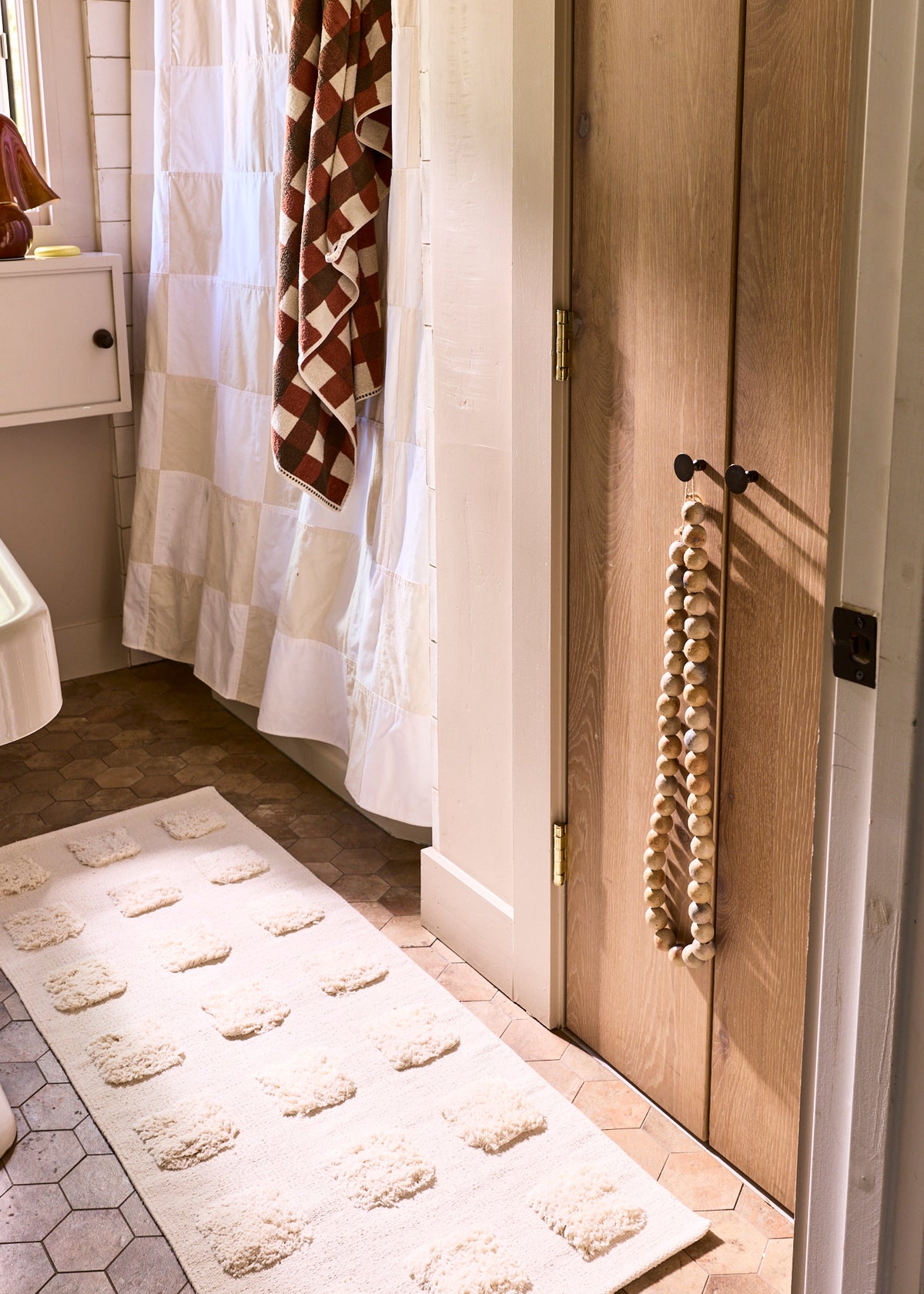 cream colored runner wtih square texture in a terracotta bathroom. 