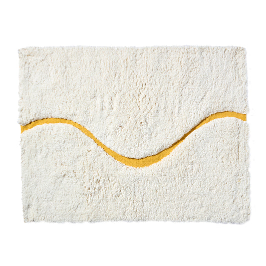 White bath mat in 21"x31" size with yellow curvy path stripe contrast shot against a white backdrop.