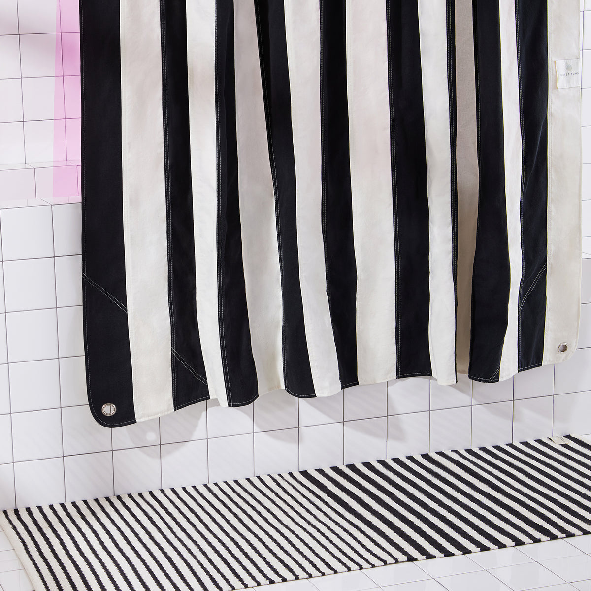 black and white striped runner with black and white striped curtain in white tiled set. 