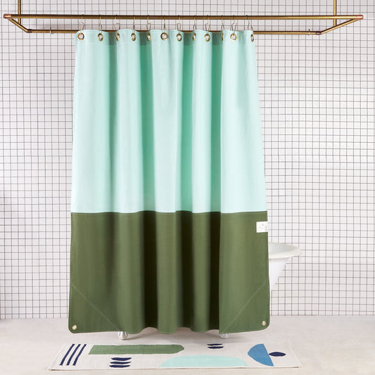 color blocked green two tone curtain hanging in white tiled bathroom 