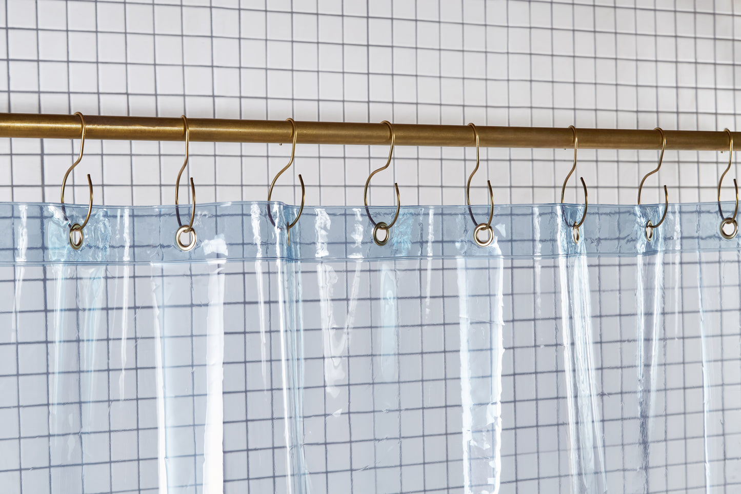 Sun Shower Atlantic detail view of grommets and hooks hanging from shower curtain rod.