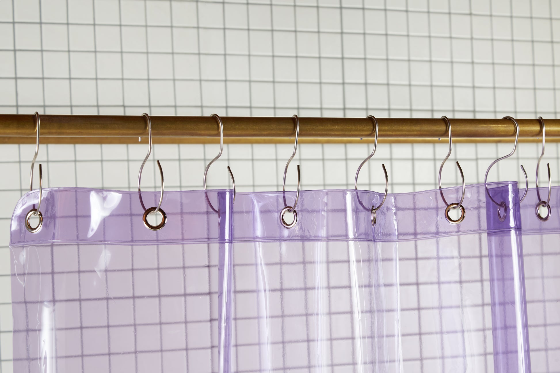 Sun Shower Thistle detail view of grommets and hooks hanging from shower curtain rod.